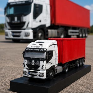 Peut inclure: Un modèle réduit de camion Iveco blanc avec un conteneur rouge, portant l'inscription HI-WAY et BENIMM TRANS LTD sur la cabine. Le modèle repose sur une base rectangulaire noire, avec un camion blanc et rouge grandeur nature en arrière-plan.