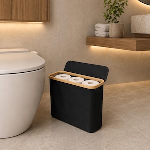 May include: A rectangular black storage bin with a light wood-toned rim and a matching hinged lid. The bin is designed to hold three rolls of white toilet paper, which are visible inside the container, positioned side-by-side in a row.