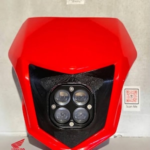 May include: A bright red motorcycle headlight fairing featuring a central black housing with four circular LED projector lenses. The unit includes the Honda CRF logo and the text 13-24 printed at the bottom left, with a Vismina logo at the top.