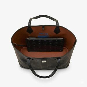 Puede incluir: Bolso tote negro con una bolsa negra a juego en el interior. El bolso tote tiene un patr&oacute;n texturizado y dos asas. El interior es marr&oacute;n con texto azul. La bolsa tiene cierre de cremallera y un patr&oacute;n repetitivo.