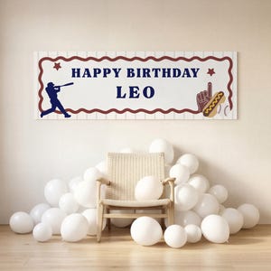 May include: A rectangular birthday banner with a white background featuring thin vertical grey stripes. The text reads HAPPY BIRTHDAY LEO in dark blue. It includes a dark blue baseball player silhouette, a brown foam finger, and a hot dog.