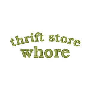 May include: Olive green text on a white background reads "thrift store whore" in a stylized, arched font. The text is centered and the overall design is simple and clean.