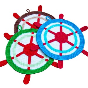 Op de afbeelding: Drie gehaakte pottenlapjes in de vorm van scheepswielen. De pottenlapjes zijn in rood, wit, groen, blauw en bruin.