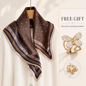 May include: A brown square scarf with a small white dot pattern and a decorative border in blue, gold, and white. Included is a gold-toned metal scarf ring shaped like a white butterfly, with text reading FREE GIFT Butterfly Scarf Ring Included.