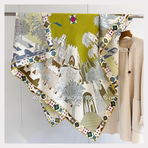 May include: A square scarf made of 40% silk and 60% wool, measuring 135 x 135 cm. The scarf features a detailed illustration of stone towers, archways, and trees in shades of olive green, cream, and grey, with a geometric border pattern.