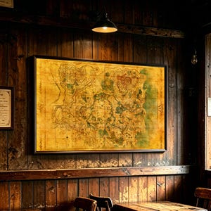 May include: A rectangular wall art print featuring a detailed, aged-style fantasy map with a yellowed parchment background, intricate black line work, and green topographical accents, enclosed in a thin black frame on a dark wood panelled wall.