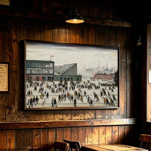 May include: A framed landscape painting depicting a large crowd of people walking towards a stadium with a red flag on top. The scene features a muted colour palette with industrial buildings in the background under a pale, overcast sky.