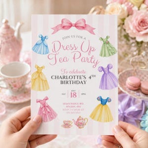 May include: A rectangular invitation card with a light pink and white striped background featuring a pink bow at the top and six watercolor-style dresses in blue, green, yellow, purple, and pink. The text reads Join Us for a Dress Up Tea Party to celebrate Charlotte's 4th Birthday, July 18, 2pm, 12345 Ridge Rd, Solon, OH, RSVP to Mom at 555.555.5555.