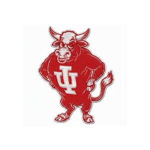 May include: A red embroidered patch featuring a cartoon bull mascot with white accents. The bull is wearing a jersey with a white "IU" logo and holding a bottle. The patch has a white border and is set against a white background.