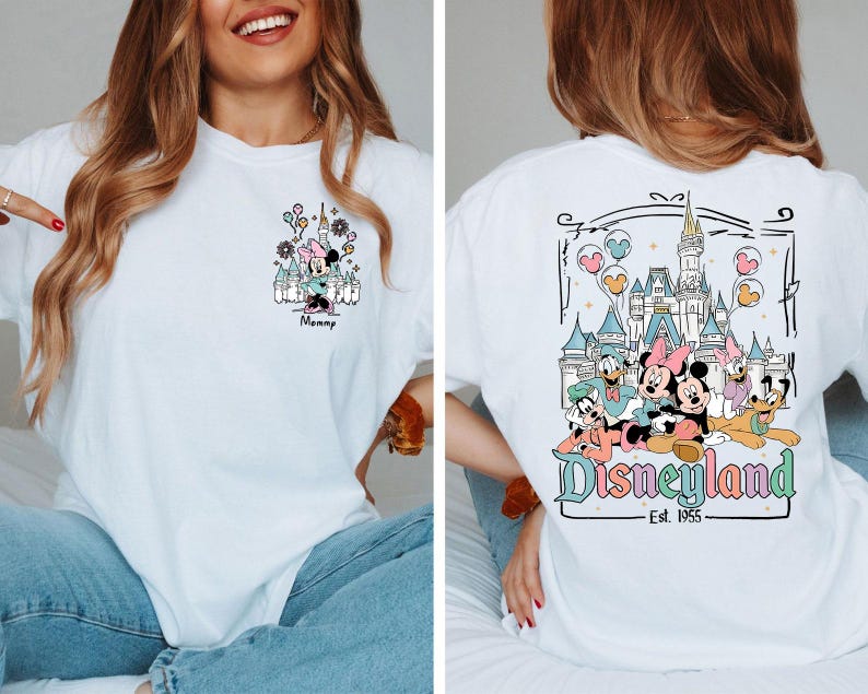 May include: A white t-shirt featuring a small graphic on the front left chest of Minnie Mouse in front of a castle with the text Mommy. The back displays a large graphic of Mickey, Minnie, Donald, Daisy, Goofy, and Pluto at a castle with Disneyland Est. 1955.