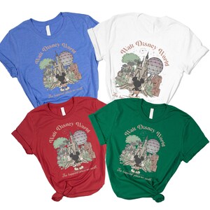 May include: Four t-shirts in blue, white, red, and green, each featuring a graphic of Mickey Mouse in front of a castle and a hot air balloon. The text "Walt Disney World" and "The happiest place on earth" are printed on each shirt.