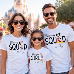 Pode incluir: Tr&ecirc;s camisetas brancas com gr&aacute;ficos de personagens da Disney e texto. A camiseta da esquerda diz Birthday SQUAD Mommy com Minnie Mouse, a do centro Birthday GIRL Custom Name com Margarida e a da direita Birthday SQUAD Daddy com Mickey Mouse.