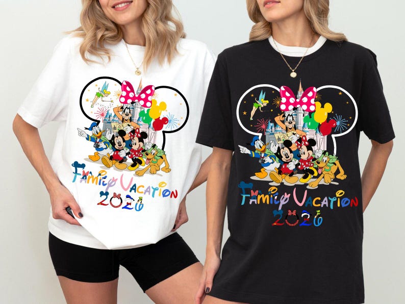 May include: A white t-shirt and a black t-shirt, each featuring a graphic of Disney characters including Mickey Mouse, Minnie Mouse, Donald Duck, Goofy, Pluto, and Tinker Bell. The design includes a castle, balloons, and the text Family Vacation 2026.