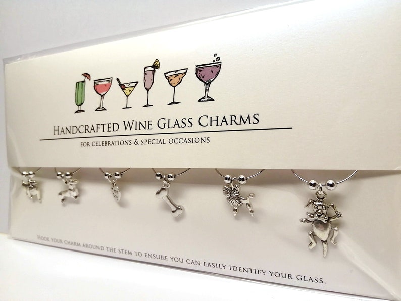 K&ouml;nnte beinhalten: Satz mit sechs silbernen Weinglasanh&auml;ngern mit verschiedenen Tiermotiven. Die Anh&auml;nger sind auf einer wei&szlig;en Karte mit dem Text "HANDCRAFTED WINE GLASS CHARMS FOR CELEBRATIONS & SPECIAL OCCASIONS HOOK YOUR CHARM AROUND THE STEM TO ENSURE YOU CAN EASILY IDENTIFY YOUR GLASS." abgebildet.
