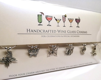 Paquete de regalo con dijes para copas de vino hechos a mano con mariposas