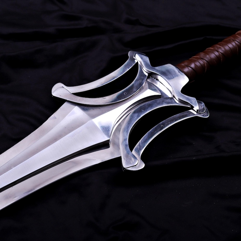 May include: A polished steel sword with a wide, double-edged blade. The hilt features a brown, leather-wrapped grip and a distinctive guard with curved, symmetrical elements. The sword is set against a black background.