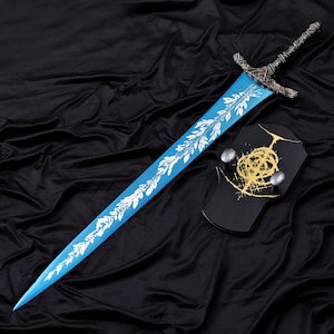 May include: A fantasy sword with a light blue blade and a silver hilt. The blade features a white leaf design. A black shield with a gold emblem and two silver knobs is also present.