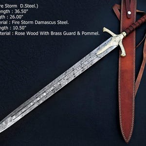 May include: A Fire Storm Damascus steel sword with a rosewood handle, brass guard, and brass pommel. The sword has an overall length of 36.50 inches, a 26.00-inch blade, and a 10.50-inch handle. It is accompanied by a brown leather sheath with straps.