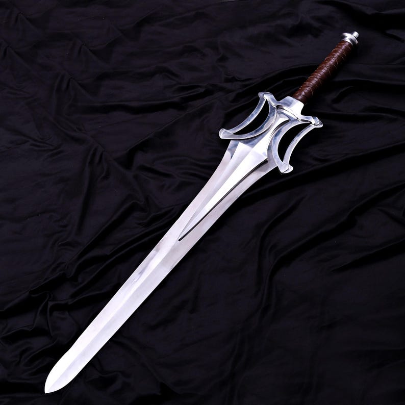May include: A silver sword with a polished blade and a brown leather-wrapped handle. The sword features a distinctive hilt design with two curved, symmetrical elements. The blade is long and tapers to a sharp point.