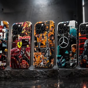 May include: Five phone cases with Formula 1 racing designs. Each case features a collage of images, including race cars, drivers, and team logos. The cases have a glossy finish and are displayed on a dark, textured surface.
