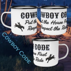 Può includere: Tre tazze in smalto bianco con bordi neri, ognuna con la silhouette nera di una persona che cavalca un cavallo imbizzarrito e il testo "COWBOY CODE Put the Horse First Respect the Ride" stampato in un carattere nero in stile western.