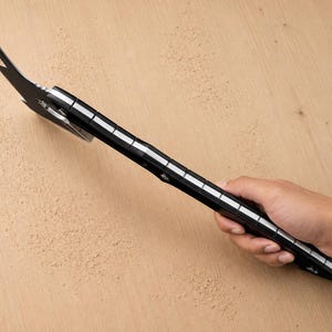 May include: A black metal multi-tool pry bar featuring a flat, angled head with a nail-pulling slot and a long handle with integrated white measurement markings along the side, designed for leverage, prying, and various manual tasks.