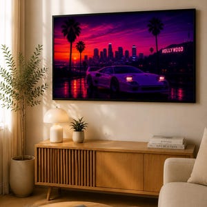 Può includere: Stampa incorniciata raffigurante un tramonto vibrante su Hollywood, con palme e un'auto sportiva. La parola "Hollywood" è illuminata al neon. La stampa è appesa sopra un mobile in legno con una lampada, una pianta e dei libri.
