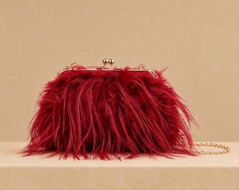Clutch burdeos de plumas con cierre kiss lock y cadena dorada para