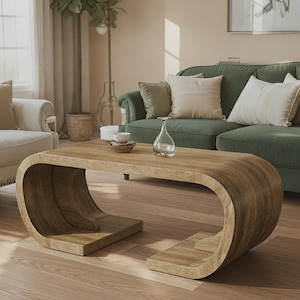 May include: A low-profile coffee table constructed from light brown wood with a continuous, curved C-shaped design that forms both the base and the tabletop. The surface features a visible wood grain pattern and a smooth, rounded edge profile.