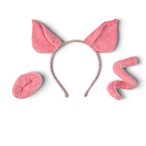 Pode incluir: Um conjunto de fantasia de porco de pelúcia rosa composto por uma tiara com duas orelhas triangulares eretas, uma peça de focinho oval separada e um rabo de porco encaracolado. Cada item é feito de um tecido macio e felpudo rosa claro.