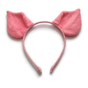 Op de afbeelding: Een roze varkensoor-hoofdband. De hoofdband is lichtroze met twee pluche, getextureerde oren. De oren zijn een donkerdere tint roze en staan rechtop. De hoofdband is gemaakt van een dun, bijpassend roze materiaal.