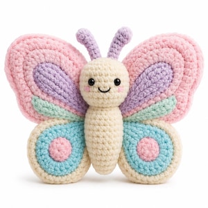 May include: A crochet butterfly toy featuring a cream-colored body and head with black embroidered eyes and a smile. The wings are layered with pastel pink, lavender, mint green, and light blue yarn, accented by pink circular details on the lower wings.