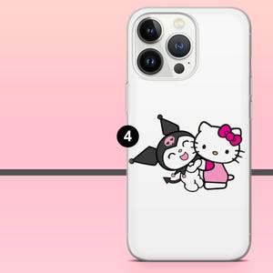Peut inclure: Coque de t&eacute;l&eacute;phone blanche avec une illustration de dessin anim&eacute; de Hello Kitty et Kuromi s'embrassant. Hello Kitty porte une robe et un n&oelig;ud roses. Kuromi est noire avec un cr&acirc;ne sur le front. La coque a un appareil photo et un flash.