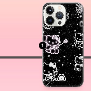 Puede incluir: Funda de tel&eacute;fono negra con un patr&oacute;n repetido de dise&ntilde;os de Hello Kitty blancos y estrellas. La funda tiene un borde transparente y un fondo negro. Un dise&ntilde;o de telara&ntilde;a es visible en la parte superior.