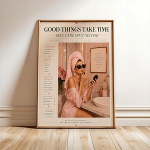 Könnte beinhalten: Ein vertikales Wandposter mit dem Text GOOD THINGS TAKE TIME und SELF CARE ISN'T SELFISH. Das Design zeigt ein zentrales Bild einer Person in einem rosa Bademantel und Handtuch beim Schminken, umgeben von Textspalten und kleinen rosa Herzen.