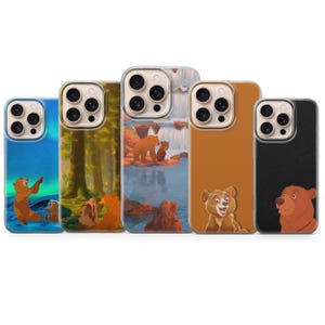 May include: Five phone cases with bear-themed designs. The cases feature various scenes, including a bear in front of an aurora borealis, a forest, a waterfall, and close-up bear portraits. The cases have a clear border.