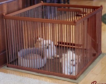 May include: Two small white dogs inside a wooden dog playpen with a burgundy finish. The playpen has a brown fabric bed inside.