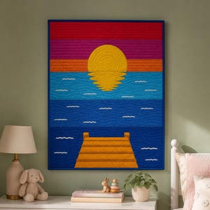 May include: A colorful wall hanging depicting a sunset over water with a pier. The artwork features a yellow sun, orange, pink, and red sky, blue water, and a yellow pier. The piece is framed in a blue border.