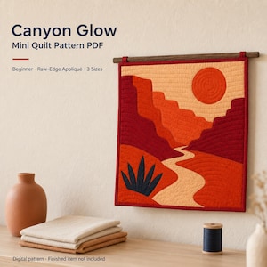 May include: A square wall hanging quilt featuring a canyon landscape with a red sun, layered orange and red rock formations, a winding path, and a dark blue plant. The text reads Canyon Glow Mini Quilt Pattern PDF, Beginner, Raw-Edge Appliqué, 3 Sizes.
