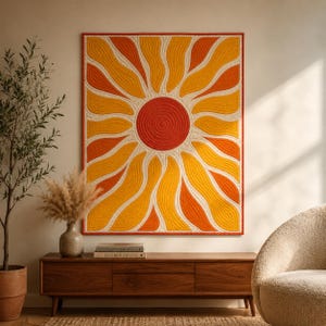 May include: A rectangular wall hanging quilt featuring a central red circular sun with radiating wavy rays in alternating shades of yellow and orange, all outlined in white stitching against a cream background with a thin red border.