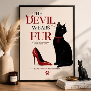 May include: A framed art print with the text "THE DEVIL WEARS FUR" and a black cat wearing a red collar. A red high heel and the words "PAWS. POWER. PURRFECTION." are also featured. A black cat figurine sits on a wooden surface.