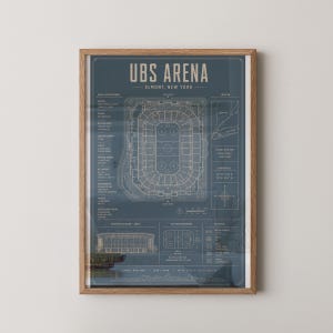May include: A framed architectural print of UBS Arena in Elmont, New York, featuring a dark blue background with white technical line drawings, including a top-down stadium layout, exterior elevation, ice rink dimensions, and venue specifications.