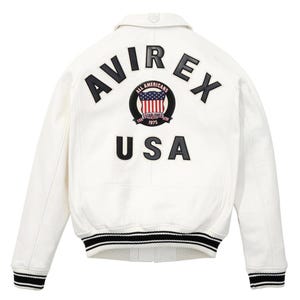 Peut inclure: Veste en cuir blanche avec des poignets et un ourlet ray&eacute;s noirs et blancs. Le dos pr&eacute;sente le texte "AVIREX" au-dessus d'un embl&egrave;me circulaire avec un drapeau am&eacute;ricain et le mot "USA".