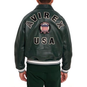 Premium sky blue leather bomber jacket for men featuring oversized AVIREX USA back embroidery and vintage streetwear fashion look