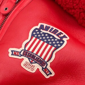 Close-up buckle collar detail on red shearling bomber leather jacket