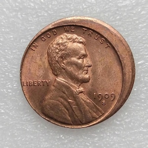 Op de afbeelding: Een koperkleurige 1909 S Lincoln cent. De voorzijde toont een profiel van Abraham Lincoln, de tekst "IN GOD WE TRUST" en "LIBERTY". Het jaartal "1909" en het muntteken "S" zijn ook zichtbaar.