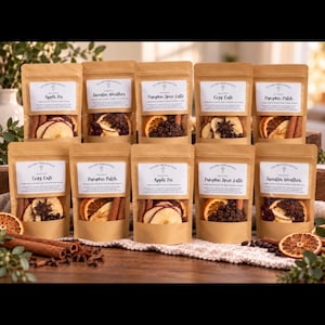 May include: Ten brown paper pouches labeled Lillard Mercantile, each containing dried fruit slices, cinnamon sticks, and star anise. The labels feature scent names like Apple Pie, Sweater Weather, Pumpkin Spice Latte, Cosy Cafe, and Pumpkin Patch.