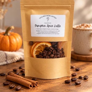 May include: A brown paper pouch containing a Pumpkin Spice Latte simmer pot kit. The label reads Lillard Mercantile and lists ingredients including coffee beans, pumpkin pie spice, cinnamon, and orange. A clear window reveals the contents.