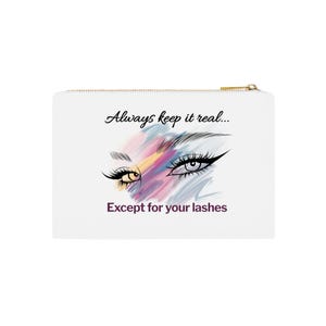 Könnte beinhalten: Weiße Kosmetiktasche mit goldenem Reißverschluss. Die Tasche zeigt eine Illustration von zwei stilisierten Augen mit langen Wimpern und dem Text "Always keep it real... Except for your lashes."
