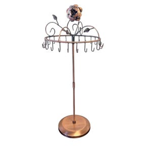 May include: A copper-colored metal jewelry display stand featuring a circular top ring with multiple hooks for hanging items. The stand is topped with a decorative metal rose and leaf design, supported by a thin central pole and a round base.
